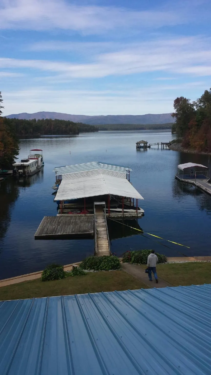 View across a lake from a newly installed blue metal roof in Ashland